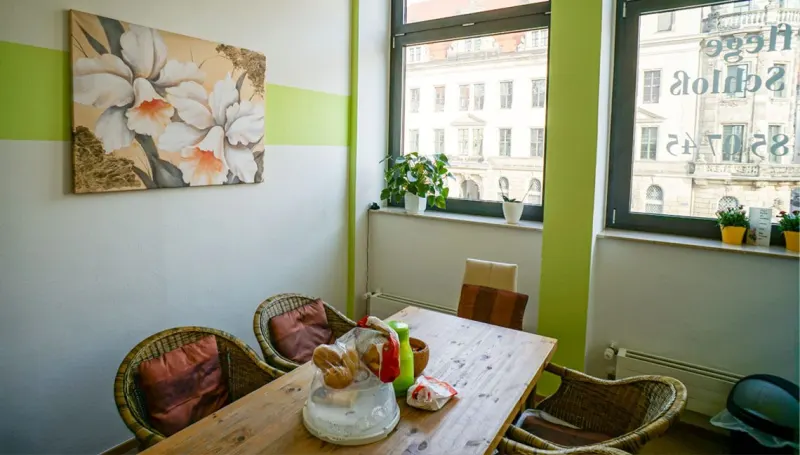 Sitzecke am Fenster mit dem Schriftzug Pflege am Schloss auf der Scheibe